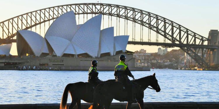 SYDNEY, AUSTRALIA - JULY 30: Two mounted police officers patrol around the edge of the harbour next to Mrs Macquarie's Chair on July 30, 2021 in Sydney, Australia. Covid-19 lockdown restrictions in hot spot local government areas have increased with masks required outdoors at all times and residents limited to movement within a 5 kilometre radius of their homes. Police have been given more authority to enforce public health orders with the help of the Australian Defence Force as Greater Sydney enters an extended lockdown through to August 28th in order to contain the highly contagious Covid-19 delta variant. (Photo by James D. Morgan/Getty Images)