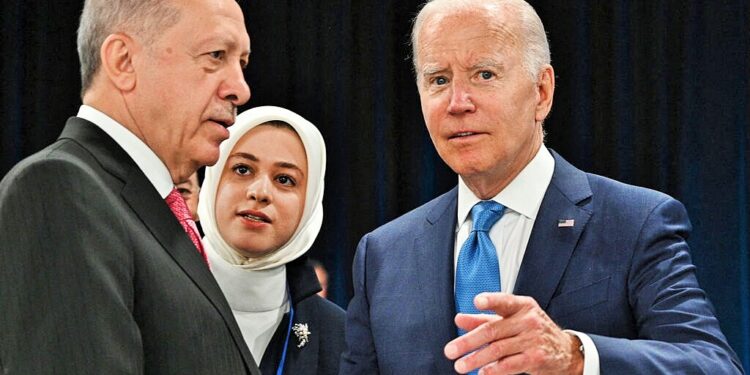 Turkey's President Recep Tayyip Erdogan (L) and US President Joe Biden shake hands at the start of the first plenary session of the NATO summit at the Ifema congress centre in Madrid, on June 29, 2022. (Photo by GABRIEL BOUYS / AFP)