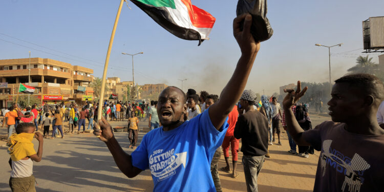 FILE PHOTO-A protester carries a flag during a rally marking the anniversary of the April uprising, in Khartoum, Sudan April 6, 2023. REUTERS/Mohamed Nureldin Abdallah