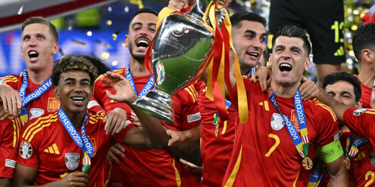 Spain's midfielder #17 Nico Williams (2L), Spain's forward #19 Lamine Yamal (4L) and Spain's forward #07 Alvaro Morata celebrate with the trophy after winning the UEFA Euro 2024 final football match between Spain and England at the Olympiastadion in Berlin on July 14, 2024. (Photo by JAVIER SORIANO / AFP)